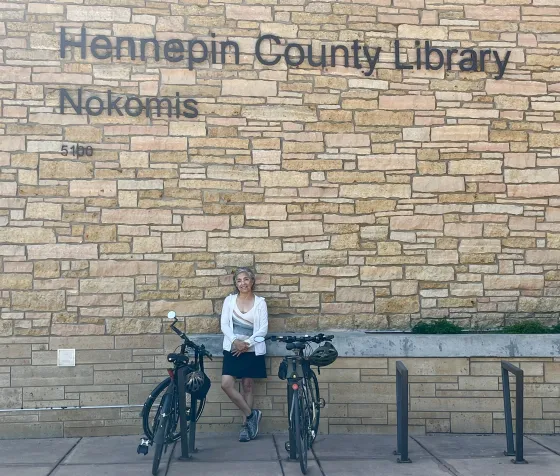 Rosa poses outside Nokomis Library beside her bike
