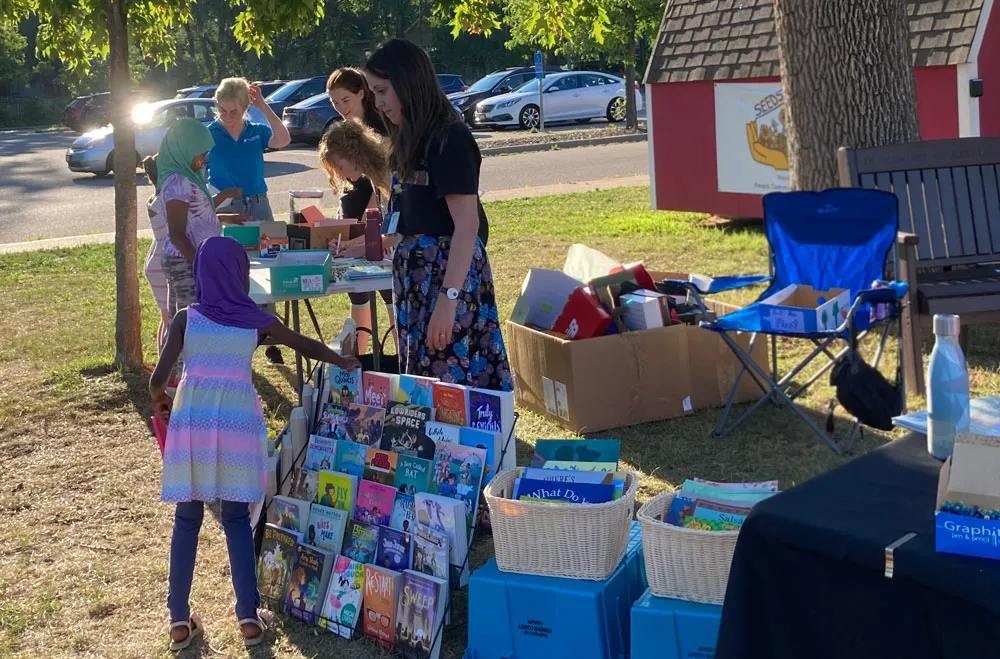 A girl picking out a new book at summer reading festival