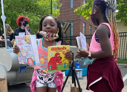 Girl holding books by library bike