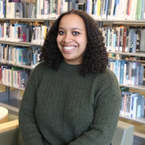 Semira Mesfin in front of stacks at Minneapolis Central Library