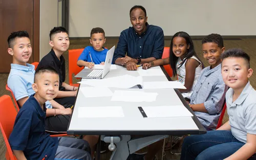 A group of young students studying with a tutor