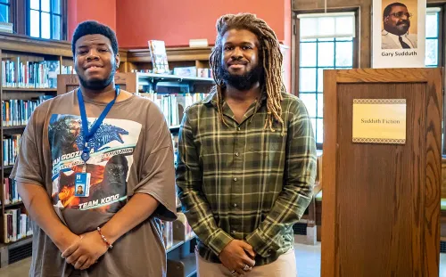 Johnny and Thomas standing among stacks at Sumner Library