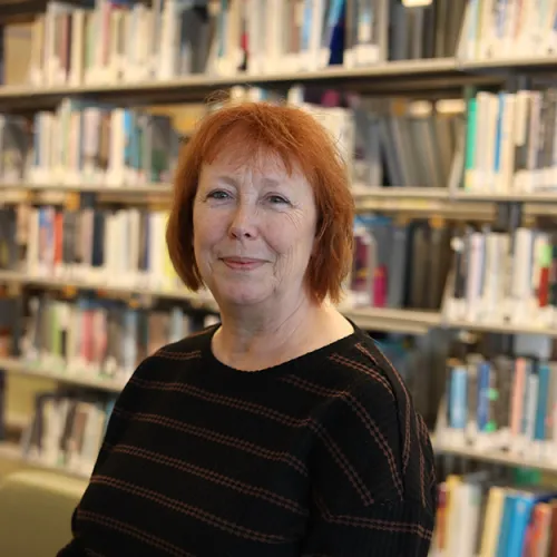 Portrait of Linda Merritt in front of the stacks at Minneapolis Central Library