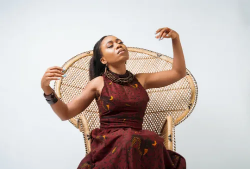 Carolyne sits on a woven chair and poses peacefully with her eyes closed in the album cover for Miss Naomi.