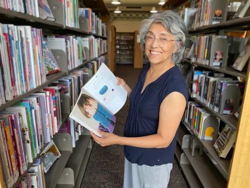 Rosa browses the knitting collection at Pierre Bottineau Library