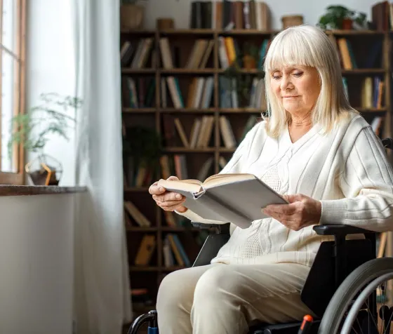 Woman in wheelchair reading a book