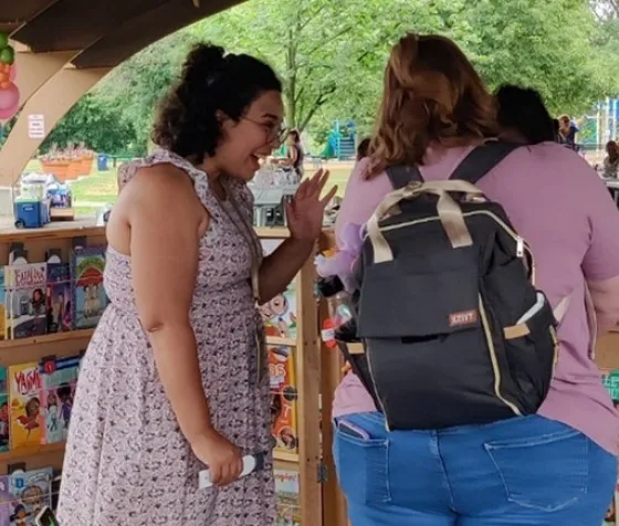 Staff helps foster care family select a book from book giveaway