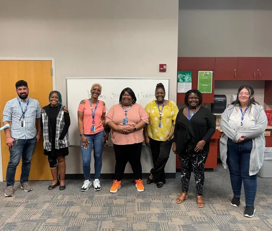 Community Based Hiring mentors and new hires stand together wearing their Hennepin County Library lanyards.