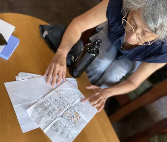 Rosa leans over a map of the library system, highlighted and noted to create the ideal bike routes.