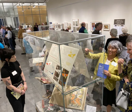 Storied Leaves exhibit opening with spectators exploring the displays