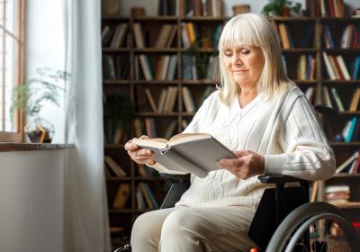 Woman in wheelchair reading a book
