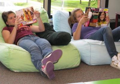 Two teens reading in beanbag chairs