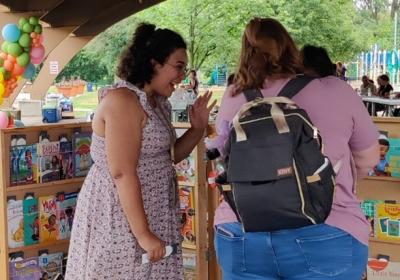 Staff helps foster care family select a book from book giveaway