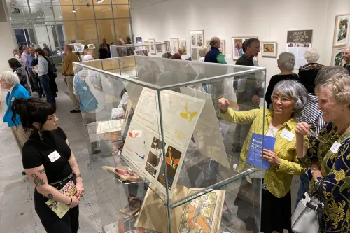 Storied Leaves exhibit opening with spectators exploring the displays