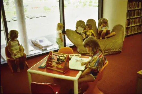 Children in the Southdale Library baseball mitt chair, 1982