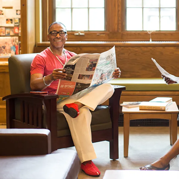 Two adults reading newspapers