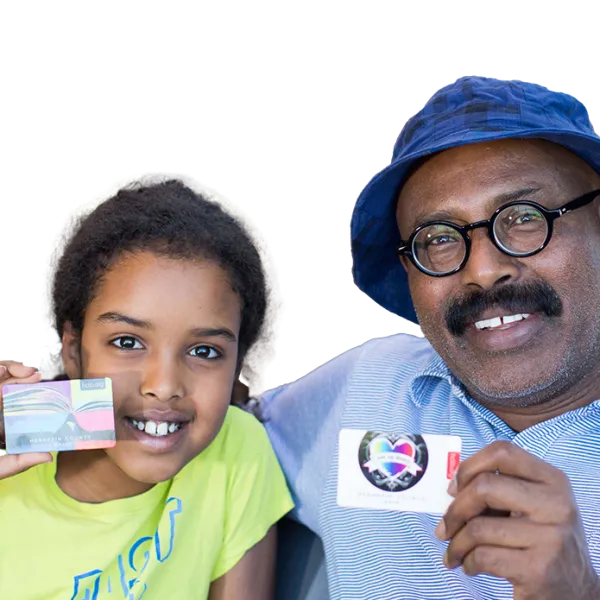 Father and daughter holding library cards and smiling 