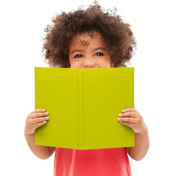 Young curly hair child hides his smile behind an open book