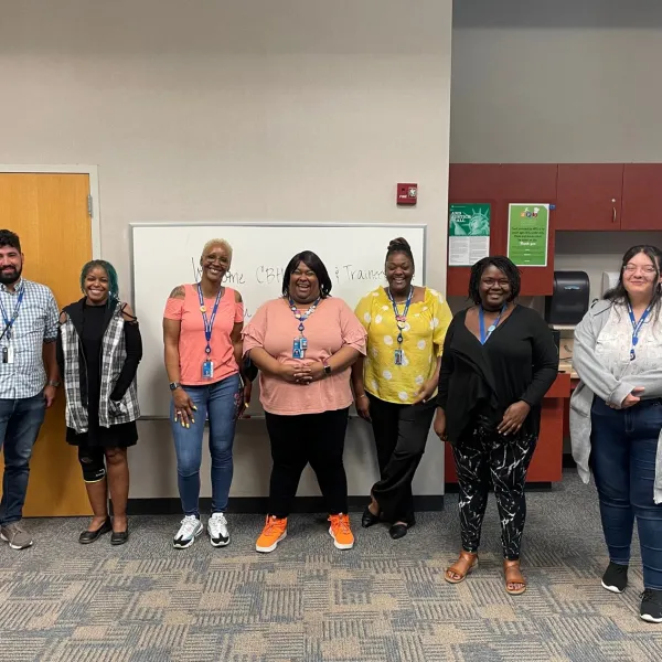 Community Based Hiring mentors and new hires pose together wearing their Hennepin County Library lanyards.