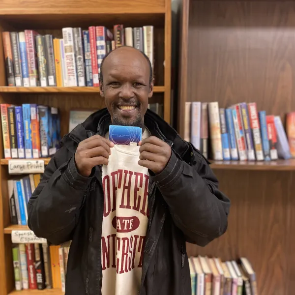 Man smiling with library card
