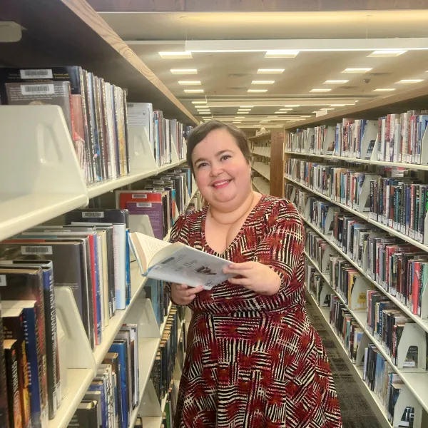 Senior Librarian Tami poses among the stacks at Ridgedale Library.